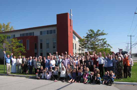 Members of Church of the Ascension waving in front of the church.