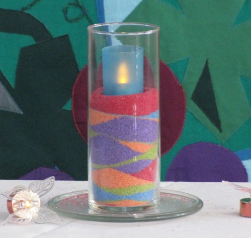 A candle of coloured sands represent the four founding churches and new members on the church building's 10th anniversary.