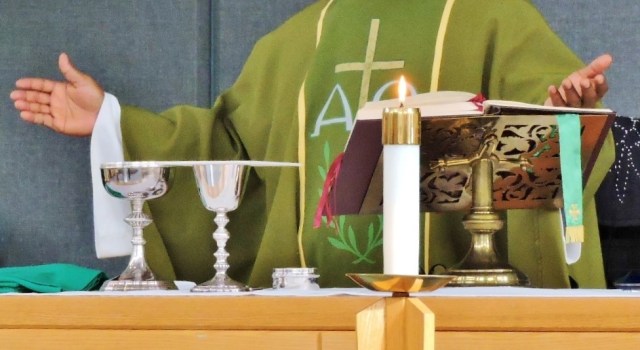 A priest stands at the altar